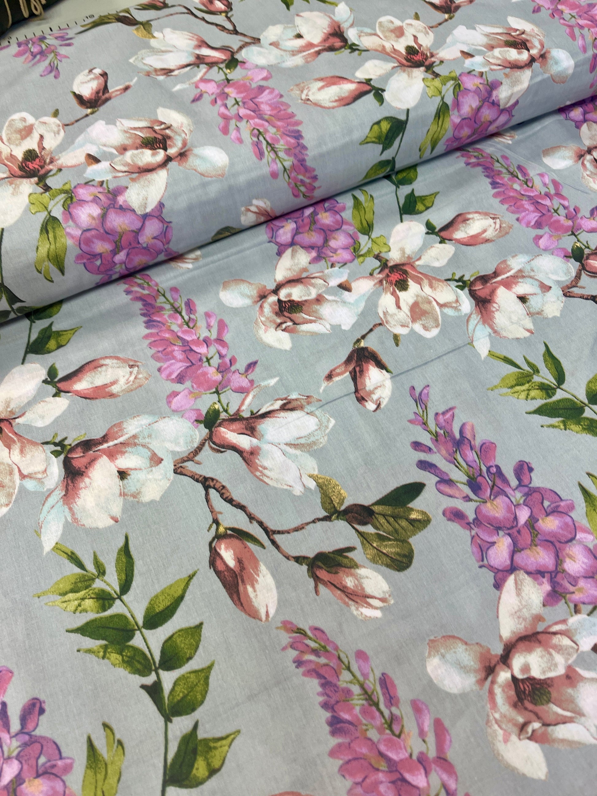 Zdjęcie z tkaniną 100% bawełnianą Magnolia na szarym tle – dostępne online Šarlotes audumi