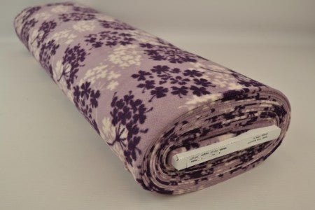 Image of fleece fabric with a tree pattern – purple/beige – available online at Charlotte's Fabrics