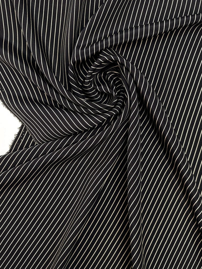 Image of 100% Italian silk fabric with a fine black striped pattern – available online at Šarlotes audumi