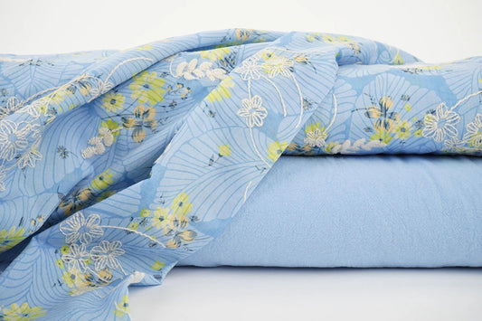 Image of embroidered cotton fabric - yellow flowers on blue 115 g/m² – available at Charlotte Fabrics