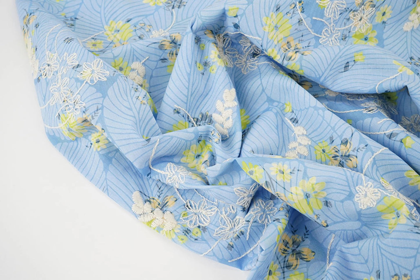 Image of embroidered cotton fabric - yellow flowers on blue 115 g/m² – available at Šarlotes audumi