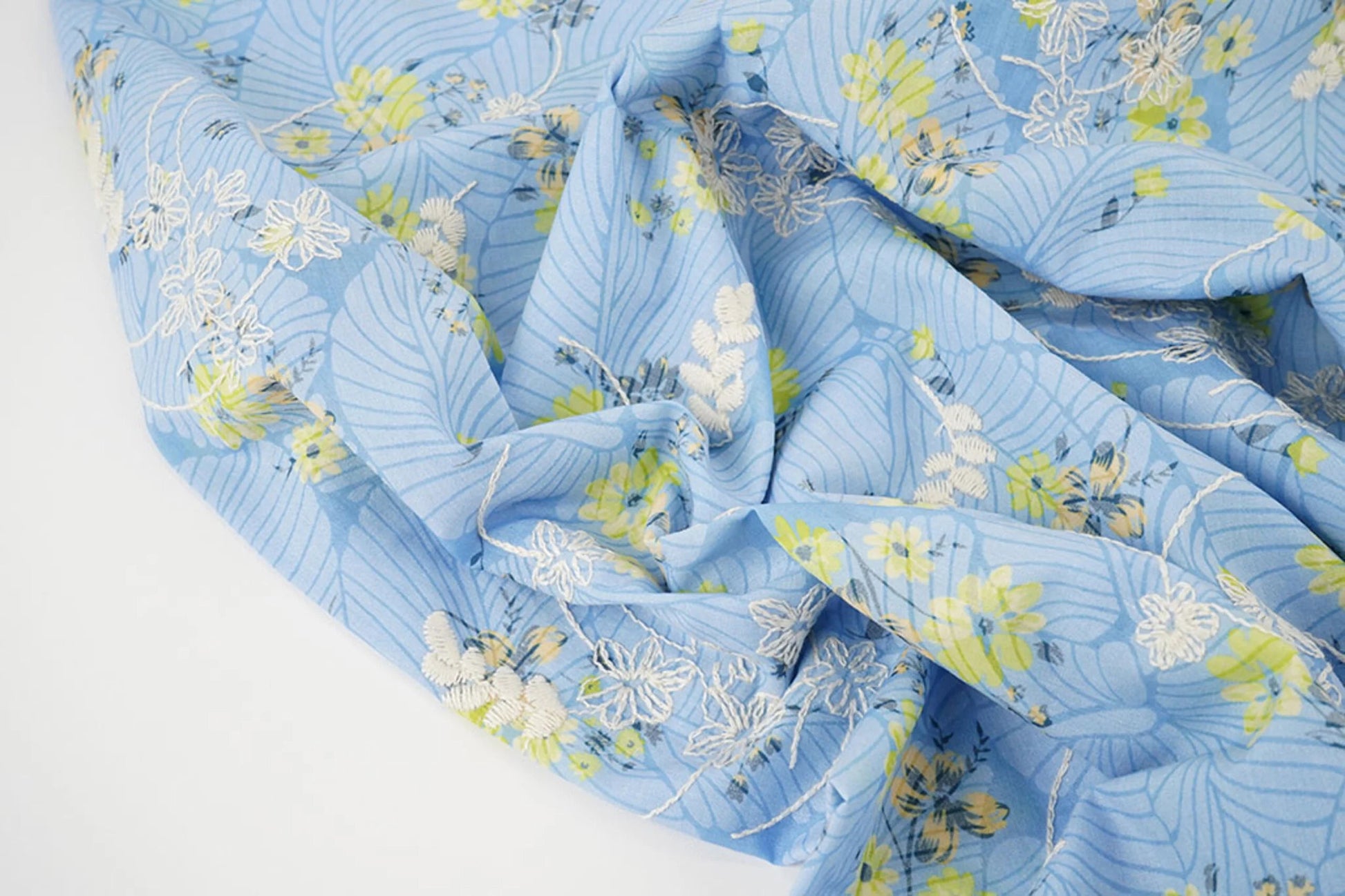 Image of embroidered cotton fabric - yellow flowers on blue 115 g/m² – available at Šarlotes audumi