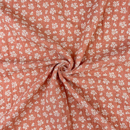 Muslin - white flowers on an orange background 130 g/m²
