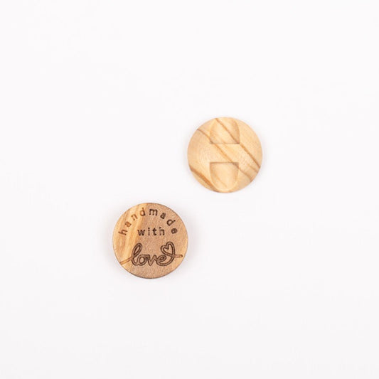 Zdjęcie guzika z drewna oliwnego Handmade with love 15 mm – dostępnego online w Šarlotes audumi