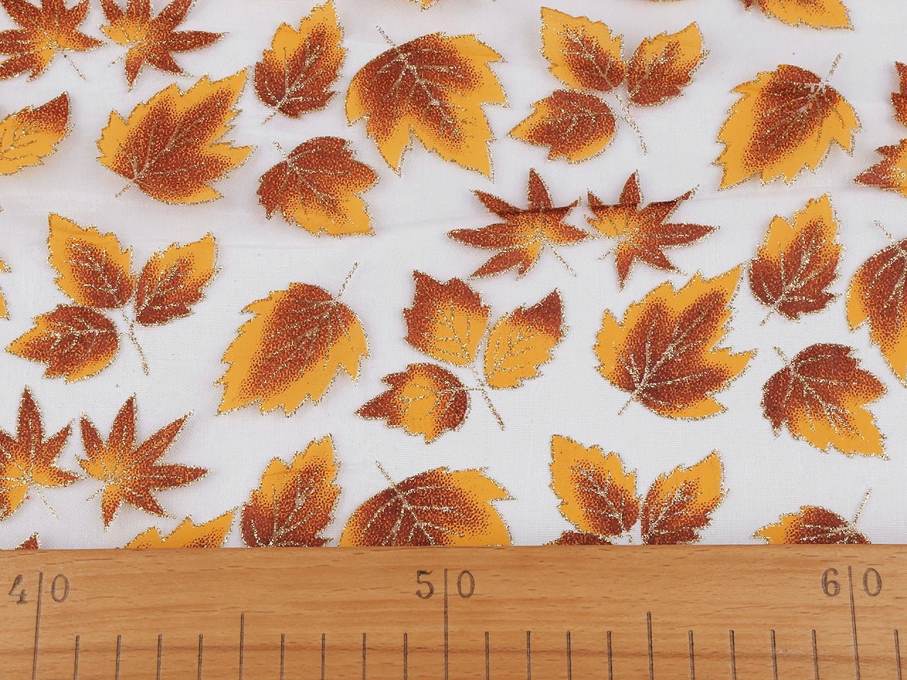 Organza fabric with a shimmering autumn leaf pattern – available online at Charlotte's Fabrics