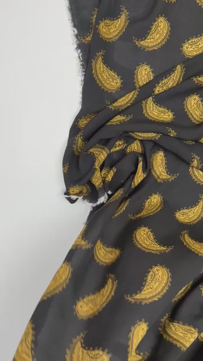 Włoska tkanina z szyfonu w 100% z wiskozy ze złotym wzorem paisley na czarnym tle – 100 g/m²