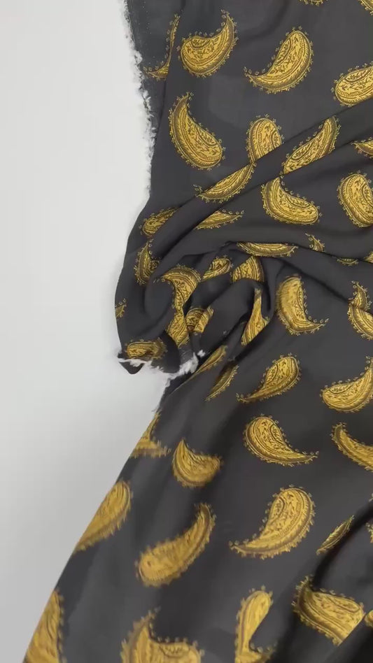 Włoska tkanina z szyfonu w 100% z wiskozy ze złotym wzorem paisley na czarnym tle – 100 g/m²