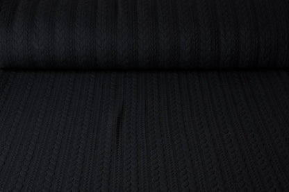 Image of knitted fabric with a knit pattern - black braids 340 g/m² – available at Šarlotes audumi